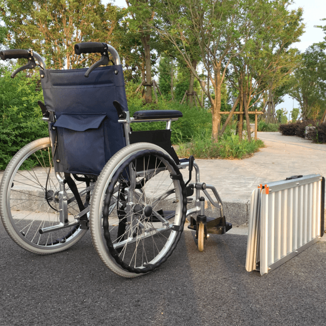 車椅子の利用者が携帯用スロープを使用して段差を乗り越える方法